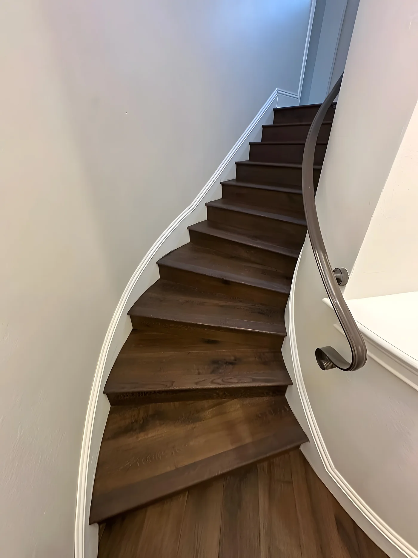 Curved staircase finished in hardwood treads with white risers