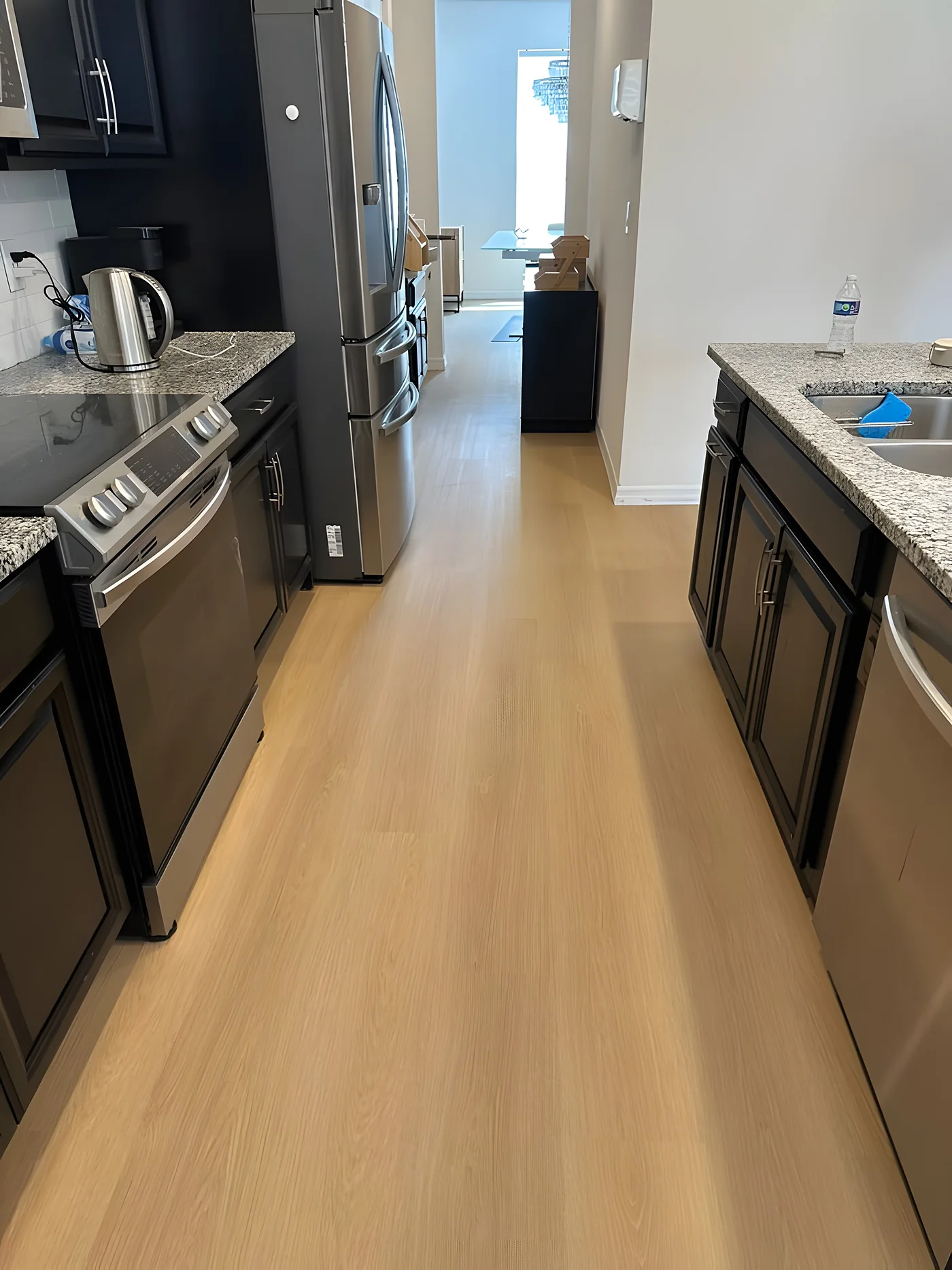Galley kitchen with light oak vinyl plank flooring