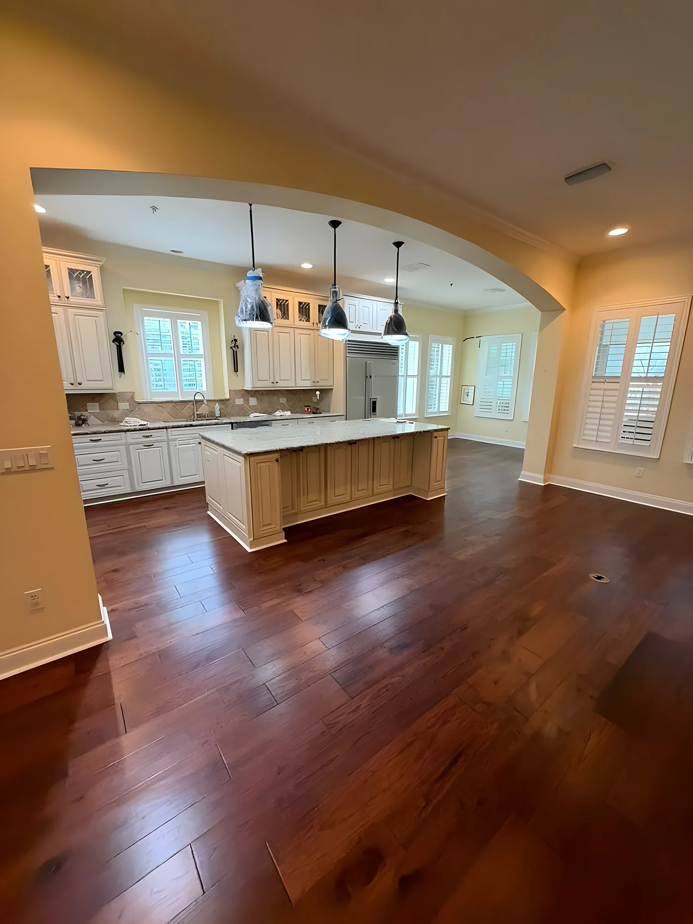Rich hardwood flooring running into an open kitchen