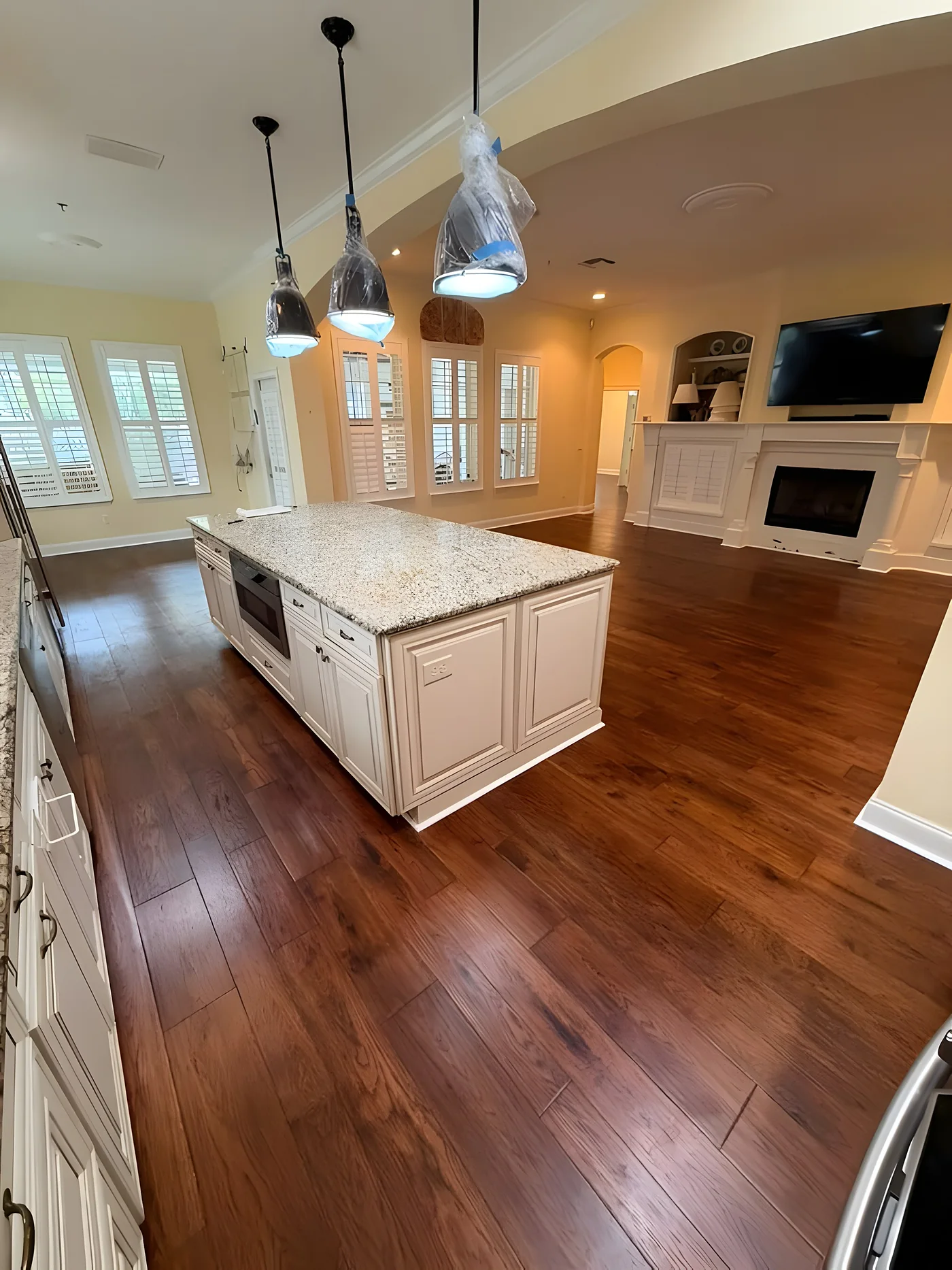 Hardwood floor around a kitchen island with pendant lights