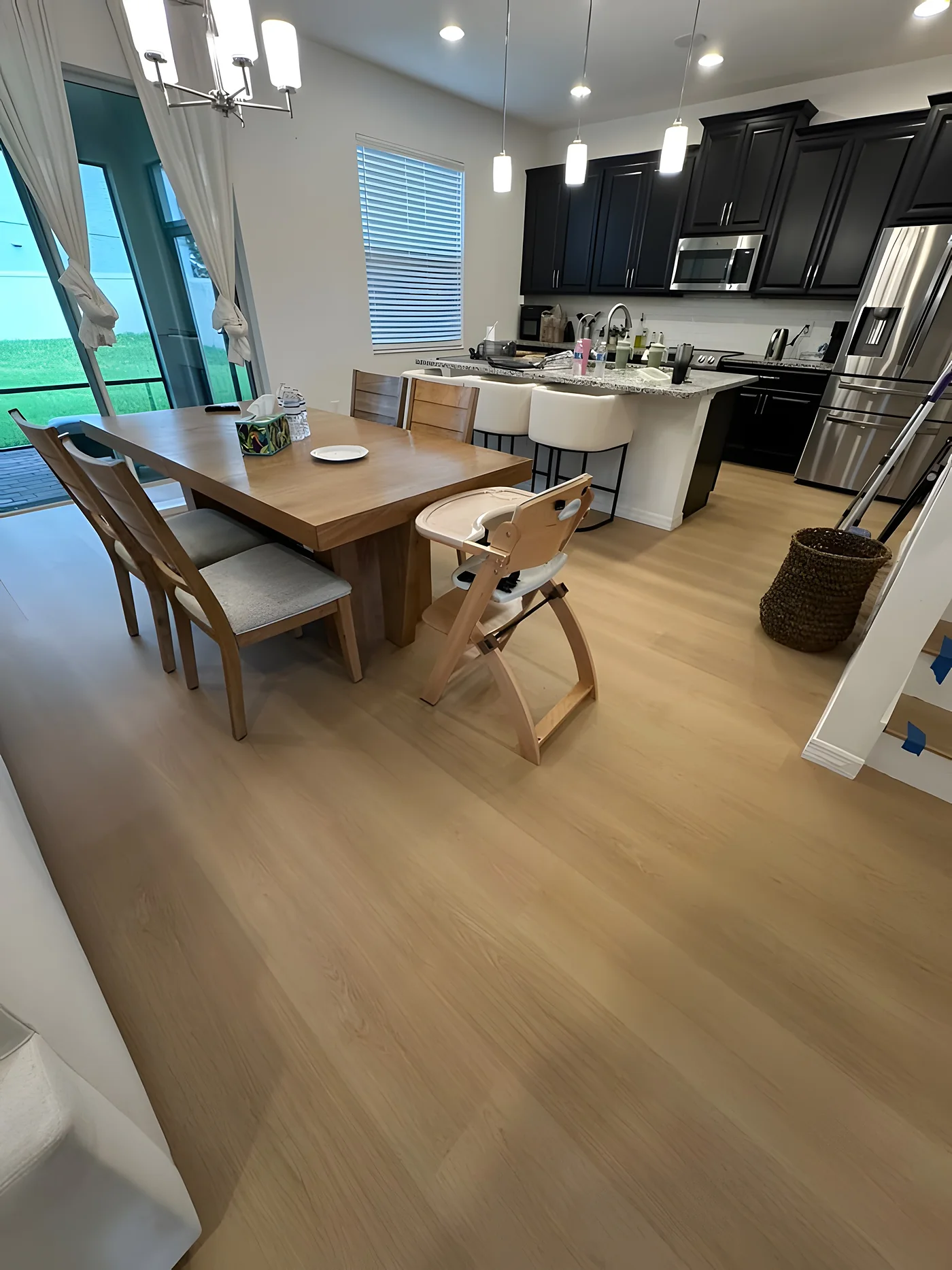 Light luxury vinyl plank floor in an open kitchen and dining area