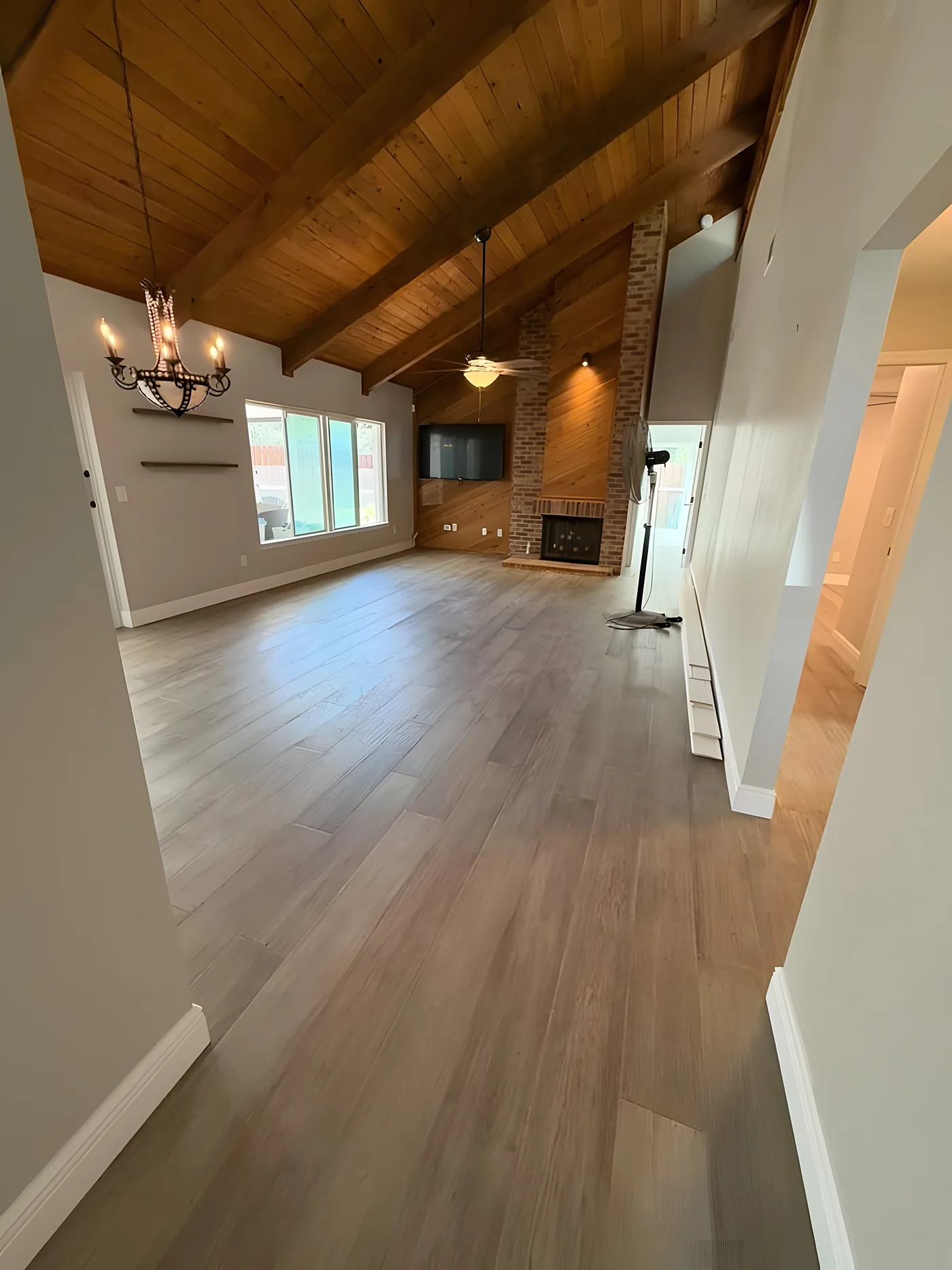 Luxury vinyl plank floor in a living room with vaulted wood ceiling
